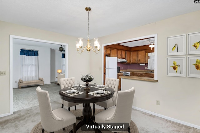 dining space with baseboards, a chandelier, and light colored carpet