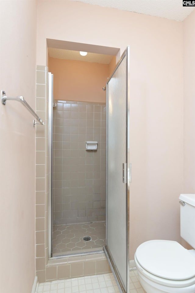 full bathroom featuring toilet, a shower stall, and baseboards