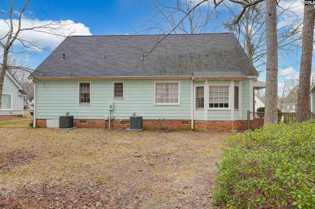 rear view of property featuring central AC, a shingled roof, and crawl space