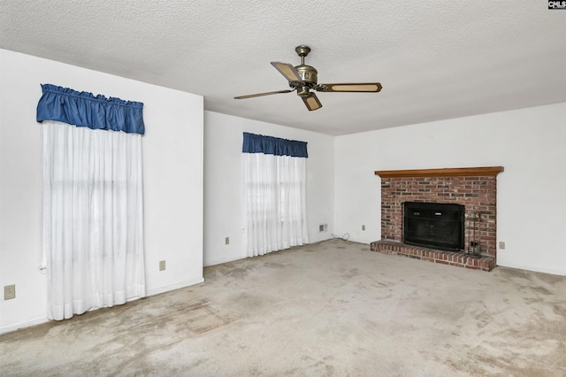 unfurnished living room featuring carpet, ceiling fan, a textured ceiling, and a fireplace