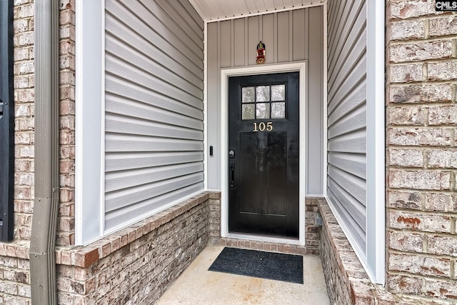 doorway to property featuring brick siding