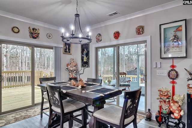 dining area featuring plenty of natural light, light wood-style flooring, visible vents, and ornamental molding