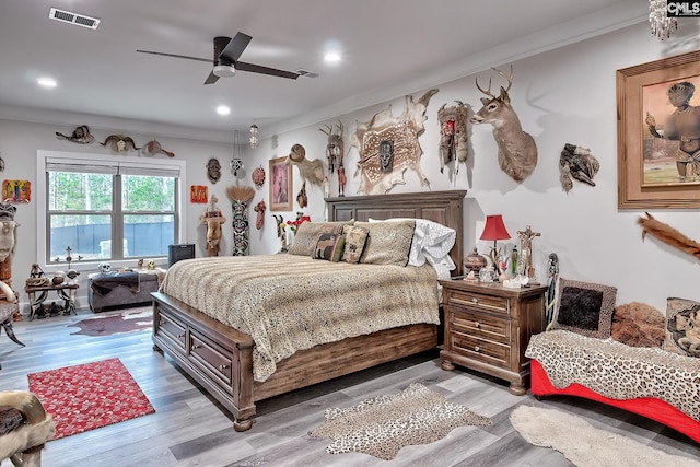 bedroom with recessed lighting, wood finished floors, visible vents, and crown molding