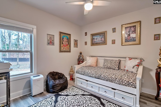 bedroom with wood finished floors, a ceiling fan, and baseboards