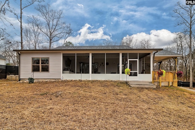 back of house with a yard and a sunroom