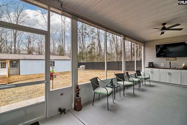 sunroom with a wealth of natural light, ceiling fan, and a sink