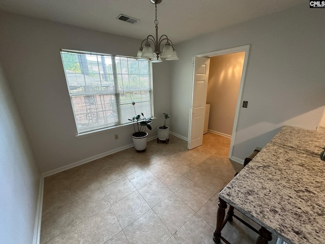 dining space with light tile patterned floors, an inviting chandelier, visible vents, and baseboards