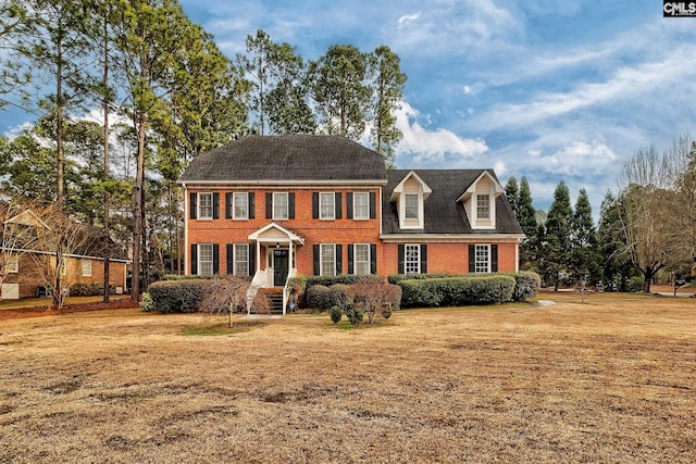 view of front of property with brick siding and a front lawn