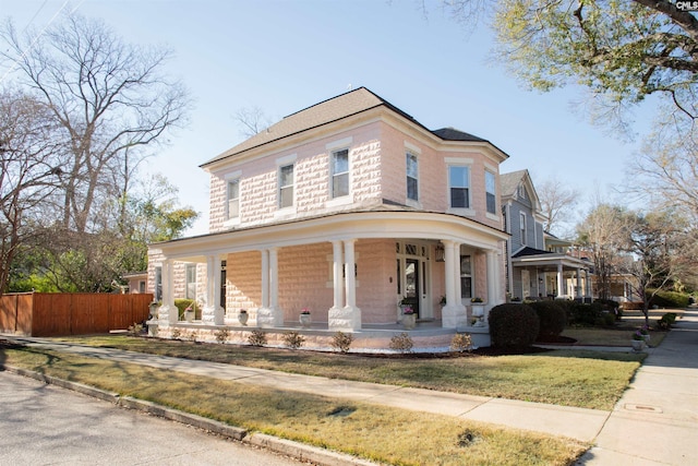 view of front of home featuring a porch and fence