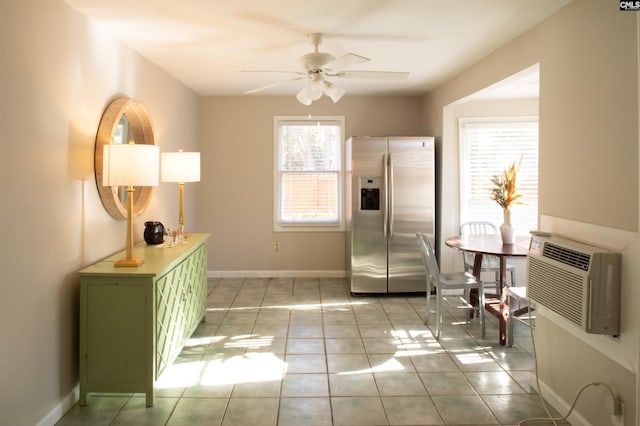 interior space featuring baseboards, stainless steel refrigerator with ice dispenser, green cabinetry, and light tile patterned flooring