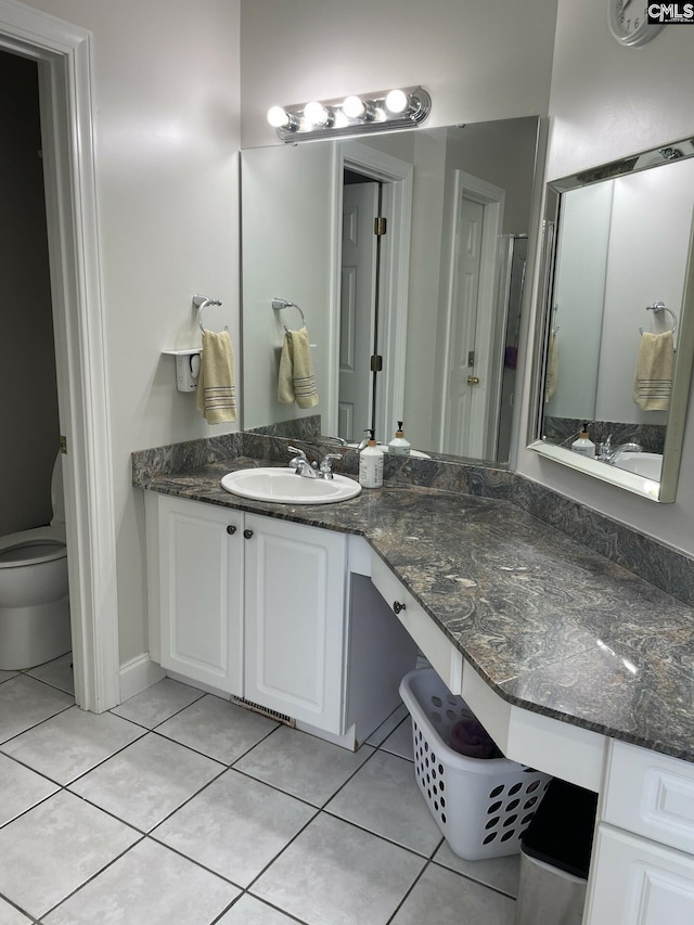 bathroom with vanity, toilet, and tile patterned floors