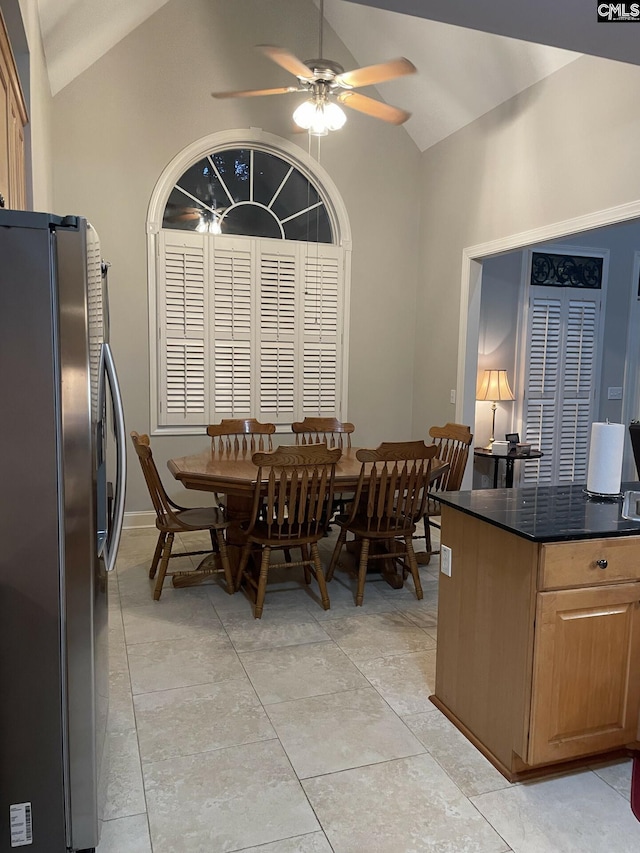 dining room featuring ceiling fan, vaulted ceiling, and light tile patterned flooring