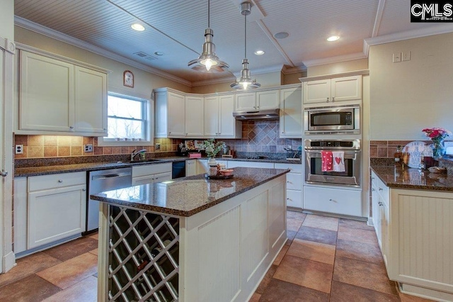 kitchen with a center island, stainless steel appliances, tasteful backsplash, hanging light fixtures, and under cabinet range hood