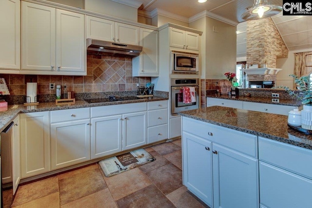 kitchen featuring white cabinets, under cabinet range hood, appliances with stainless steel finishes, and dark stone counters