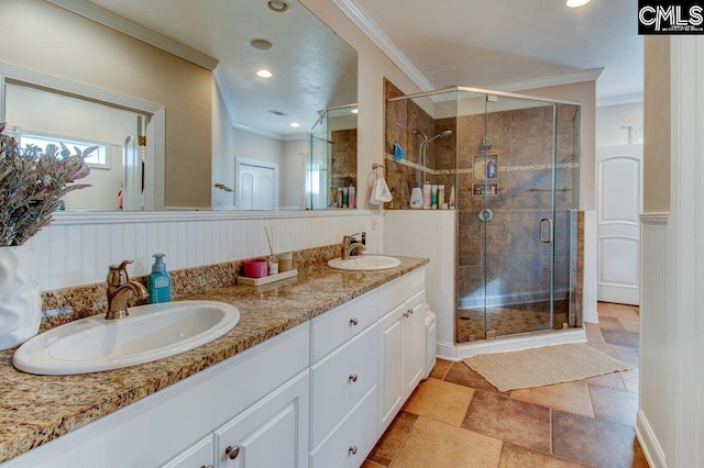 full bath with double vanity, crown molding, a sink, and a shower stall