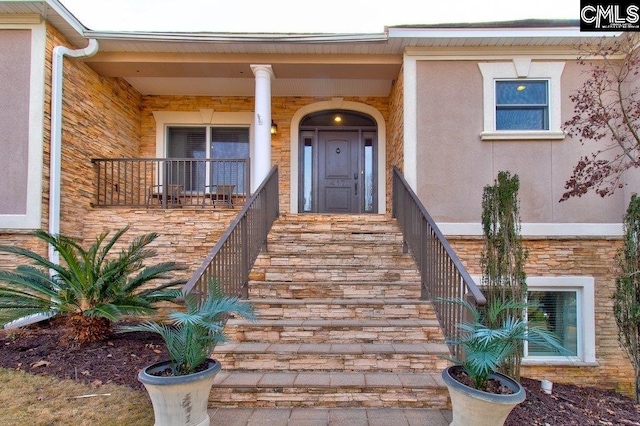 property entrance with stone siding and stucco siding