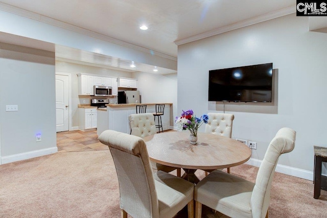 dining room featuring ornamental molding, recessed lighting, light colored carpet, and baseboards