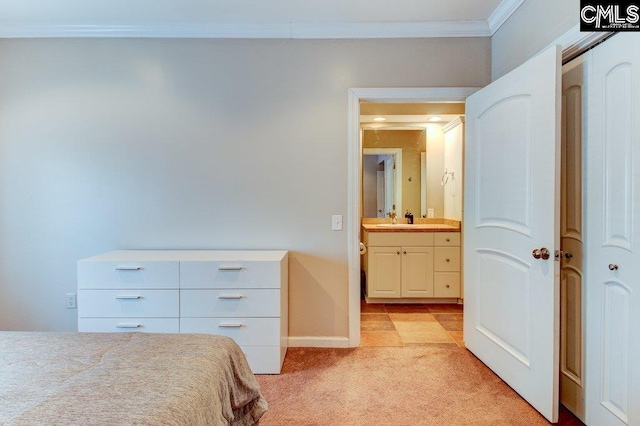 bedroom with crown molding, baseboards, a sink, and light colored carpet