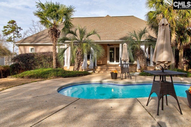 outdoor pool with a patio and a ceiling fan