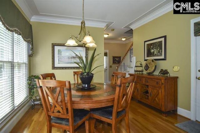 dining room with ornamental molding, stairway, baseboards, and wood finished floors