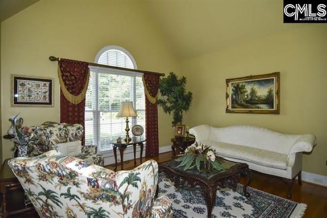 living room featuring vaulted ceiling, wood finished floors, and baseboards