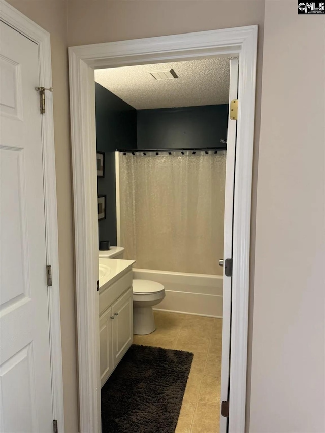 bathroom with visible vents, toilet, a textured ceiling, vanity, and tile patterned floors