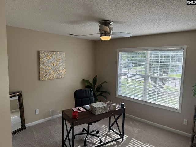 carpeted office featuring a textured ceiling, baseboards, and a ceiling fan