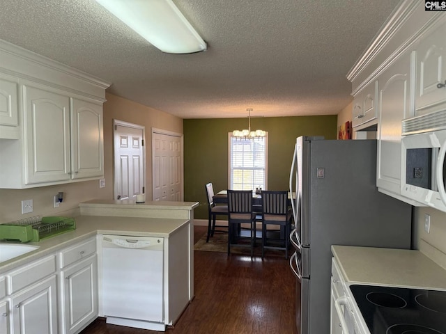 kitchen featuring white dishwasher, a peninsula, white cabinetry, light countertops, and decorative light fixtures