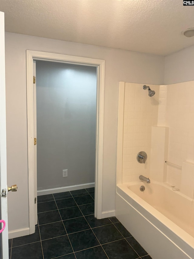 bathroom with a textured ceiling,  shower combination, tile patterned flooring, and baseboards