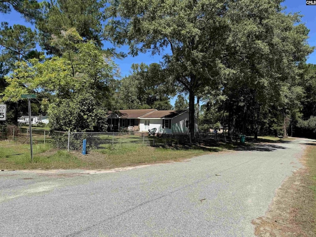 view of front of home with driveway and fence