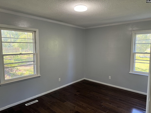 empty room with a wealth of natural light, dark wood finished floors, and visible vents