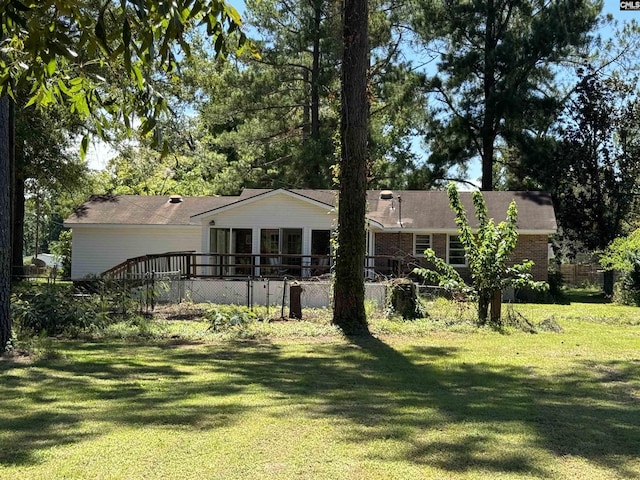 view of front of home featuring a front yard, brick siding, and fence