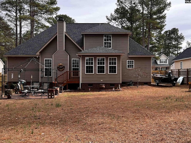 rear view of property with a patio, a yard, crawl space, roof with shingles, and a chimney