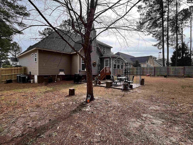 rear view of house featuring a patio, a chimney, cooling unit, and fence