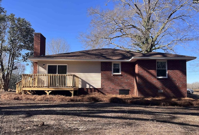 exterior space featuring a chimney, crawl space, brick siding, and a deck