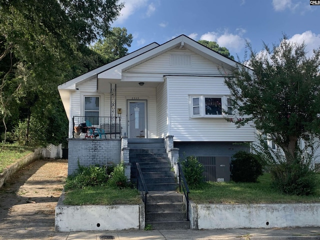 view of front of property with a porch and central AC