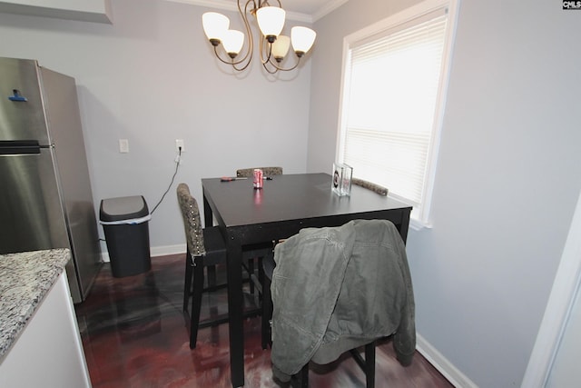 dining room featuring an inviting chandelier, crown molding, baseboards, and a wealth of natural light