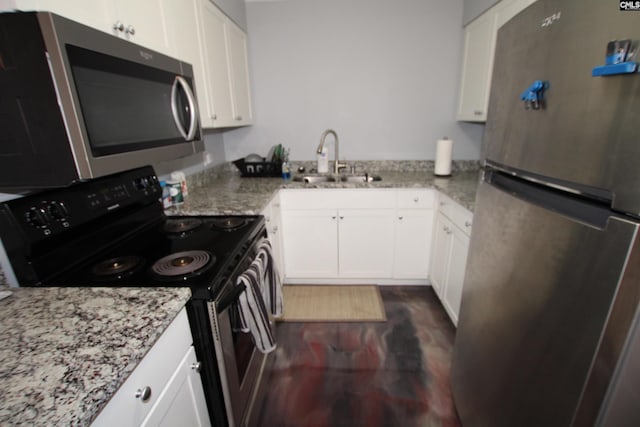 kitchen with appliances with stainless steel finishes, light stone counters, and white cabinets