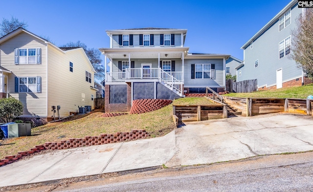 view of front of home featuring covered porch, fence, central AC, and a front yard