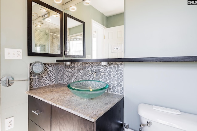 full bathroom with vanity, toilet, and decorative backsplash