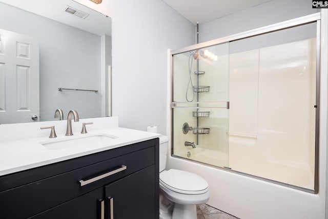 bathroom featuring toilet, bath / shower combo with glass door, vanity, and visible vents