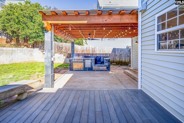 deck with area for grilling, a patio area, and a fenced backyard