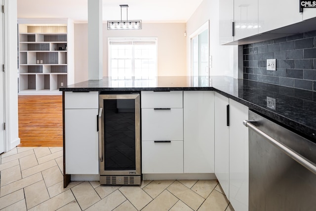 kitchen with beverage cooler, stainless steel dishwasher, decorative light fixtures, and white cabinets