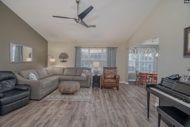 living room with a wealth of natural light, a ceiling fan, visible vents, and light wood-style floors