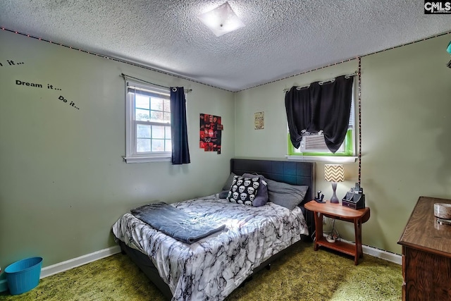bedroom with baseboards and a textured ceiling