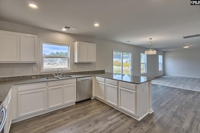 kitchen with a peninsula, a sink, white cabinets, open floor plan, and dishwasher