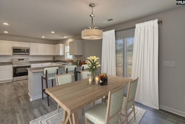 dining space with baseboards, visible vents, dark wood-style flooring, and recessed lighting