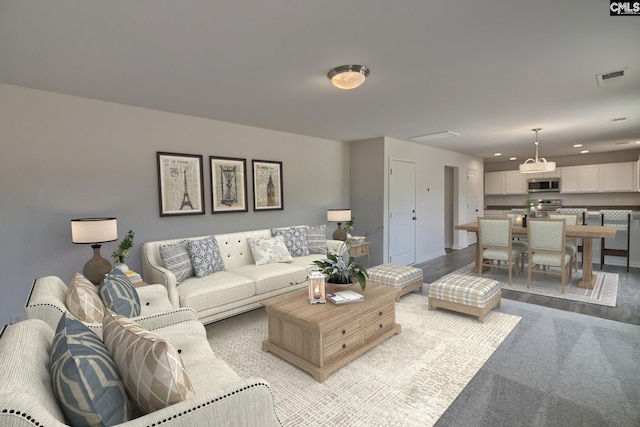 living room featuring light wood-type flooring, visible vents, and recessed lighting