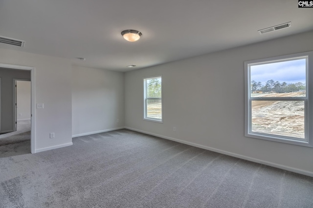 carpeted empty room with baseboards and visible vents