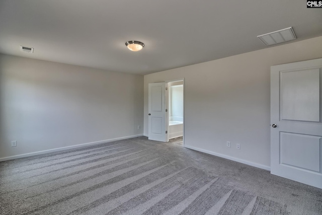 carpeted empty room featuring visible vents and baseboards